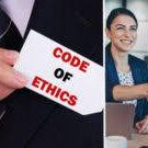 A man holding an ethics card and two women working.