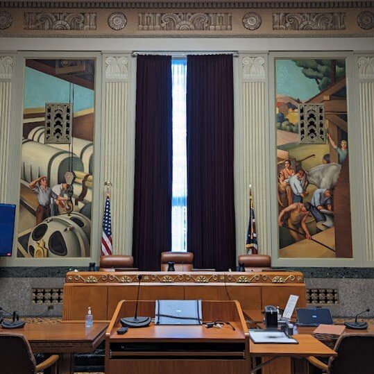 A courtroom with two large paintings on the wall.